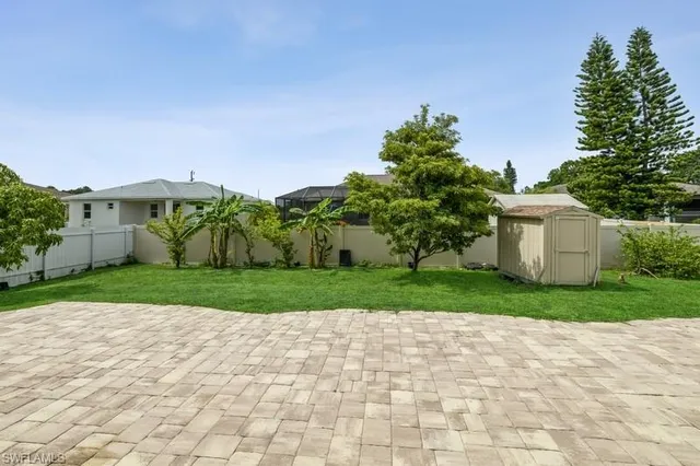 a view of a white house with a yard and plants