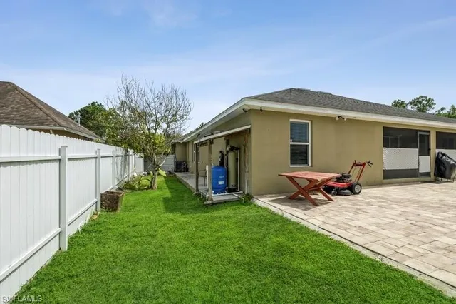 a front view of a house with a garden and chairs