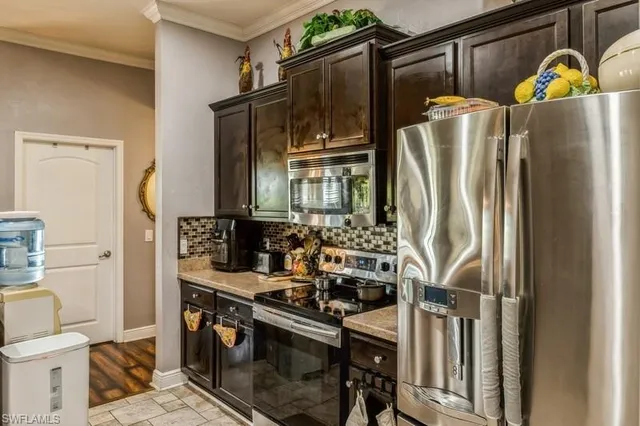 a kitchen with stainless steel appliances granite countertop a refrigerator and a stove