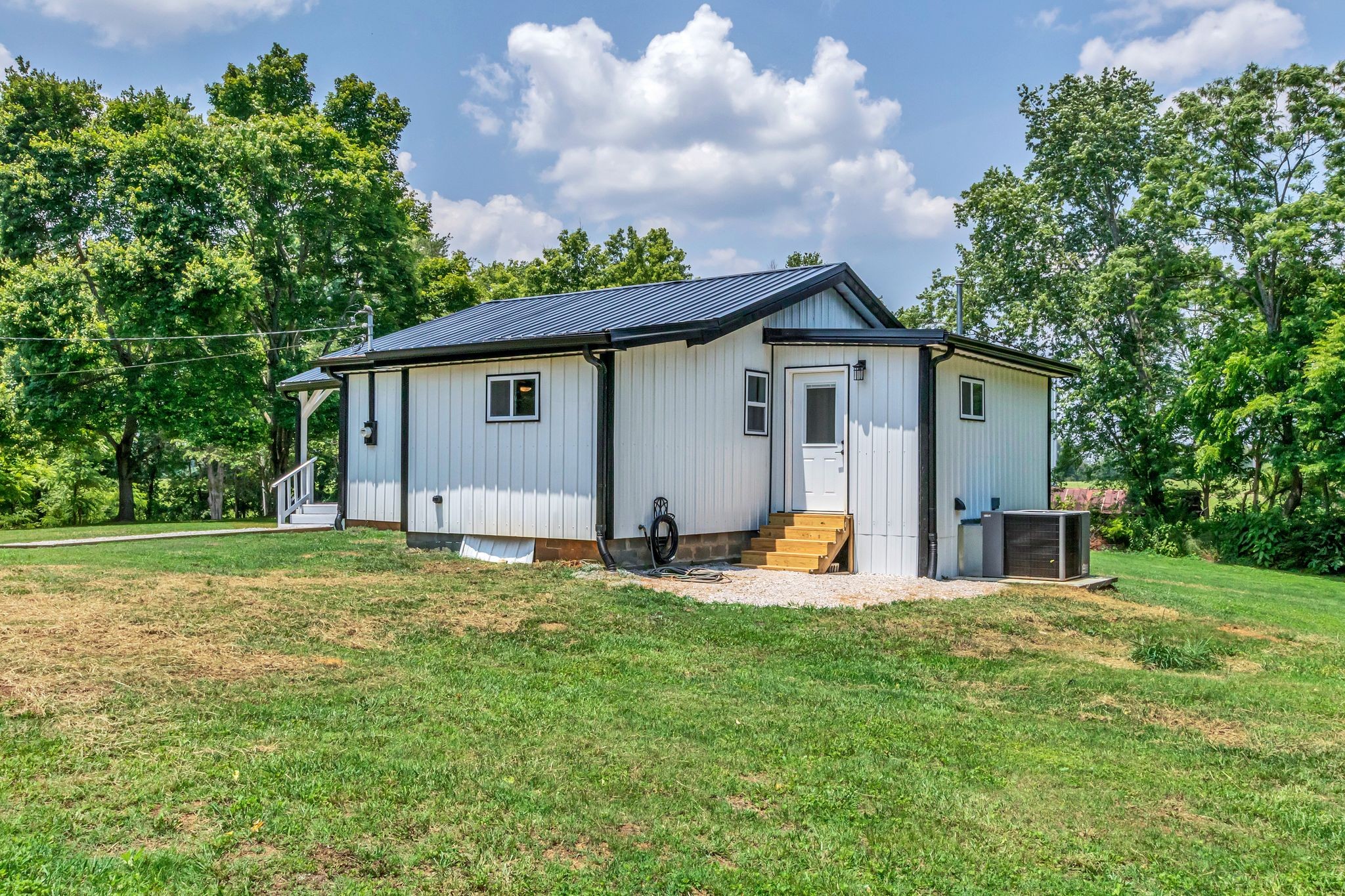 325 Francis Road Decherd, TN 37324 - Photo 22 of 27 a backyard of a house with table and chairs and a large tree