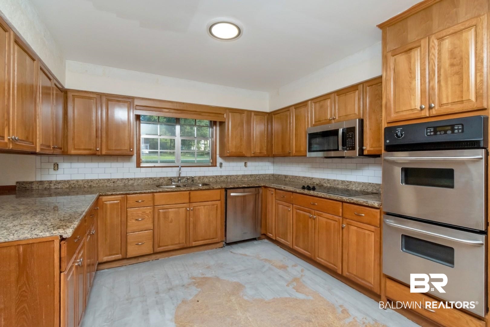 241 Suzanne Circle Mobile, AL 36608 - Photo 9 of 41 Kitchen featuring stainless steel appliances, brown cabinetry, decorative backsplash, and stone countertops