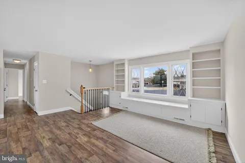 an empty room with wooden floor and a window