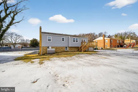 a front view of a house with a garden and trees