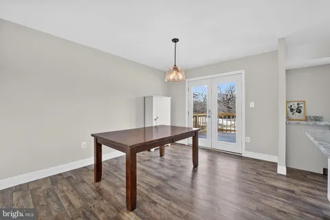 a view of a room with wooden floor chandelier and windows