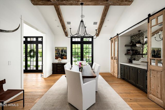 a living room with furniture wooden floor and a floor to ceiling window