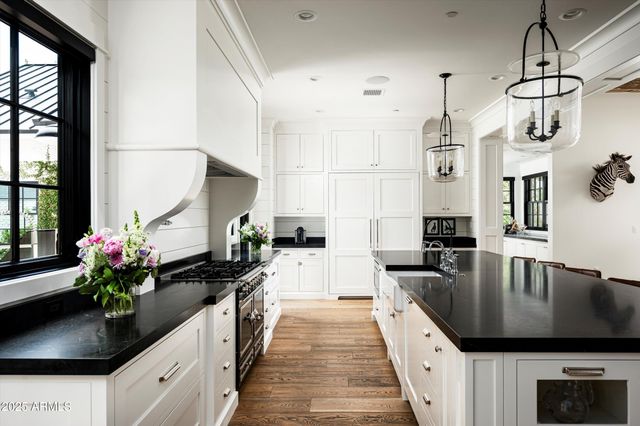 a kitchen with granite countertop white cabinets and a window