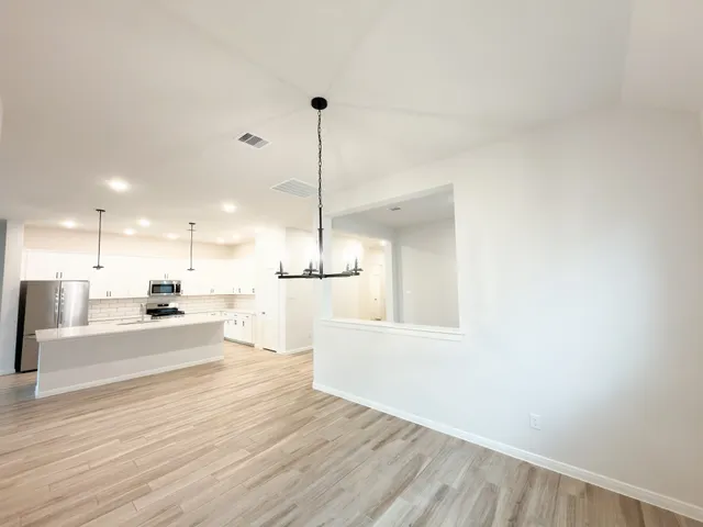 a view of a kitchen with furniture and wooden floor