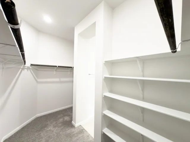a view of walk in closet with empty racks