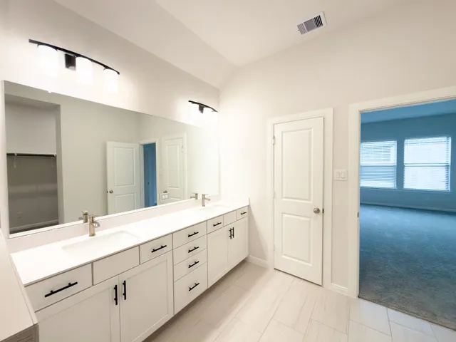 a bathroom with a double vanity sink and mirror