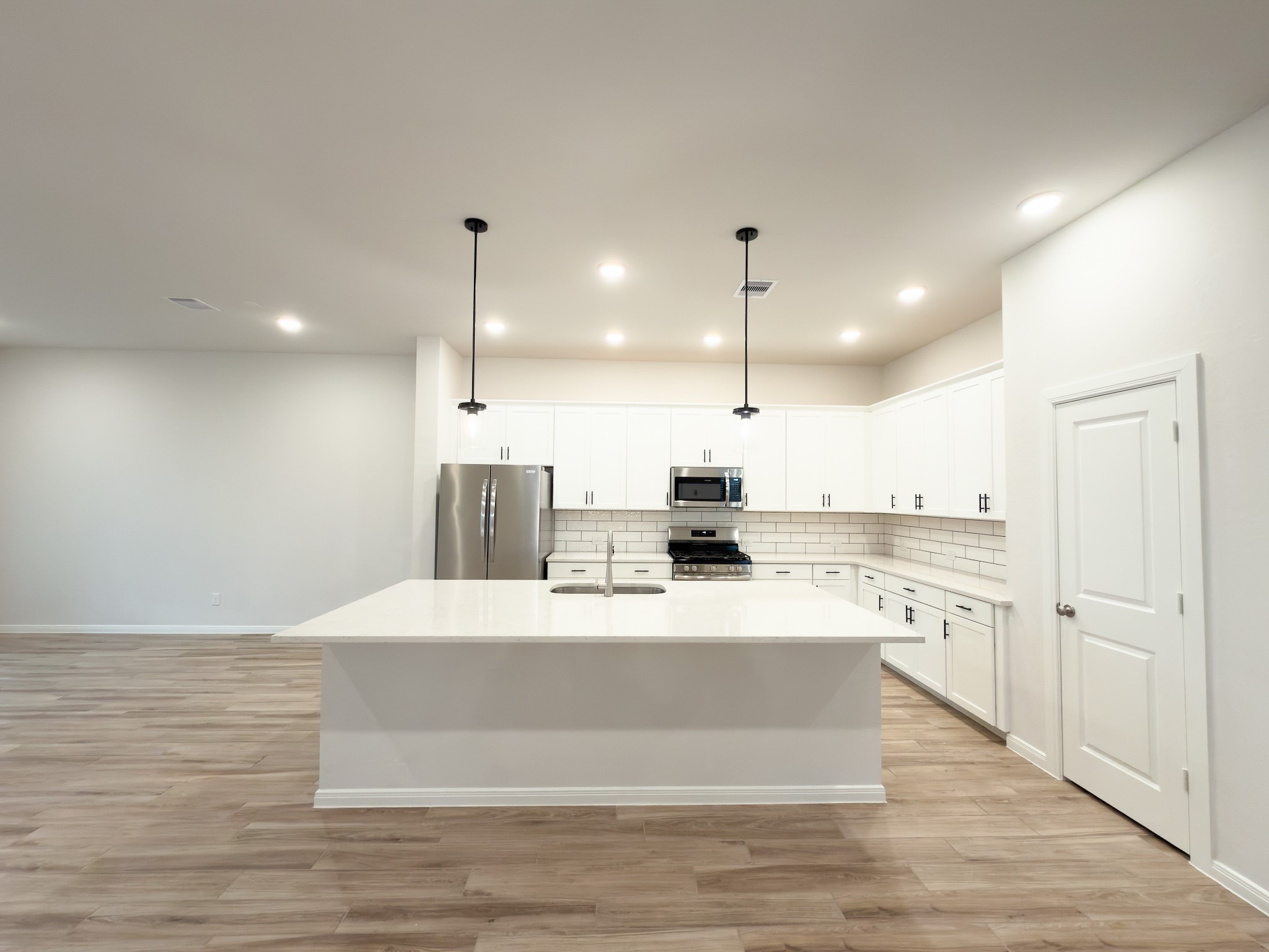 42504 Rustico Road Magnolia, TX 77354 - Photo 6 of 46 a large white kitchen with wooden floor