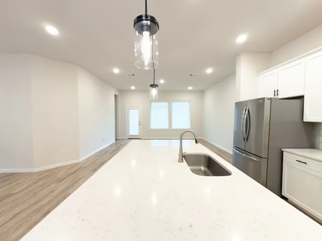 a large kitchen with kitchen island a sink stainless steel appliances and a counter top space