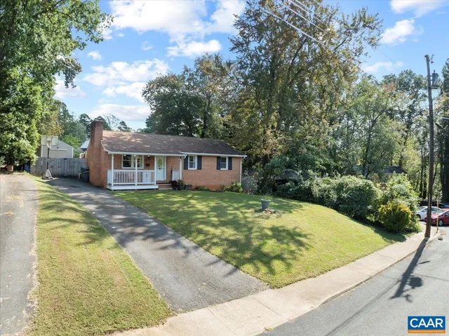 a view of a house with pool plants and large trees