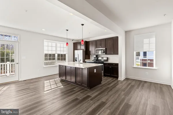 a kitchen with stainless steel appliances granite countertop a refrigerator and a stove top oven