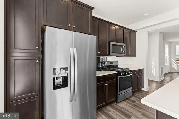 a kitchen with stainless steel appliances wooden cabinets and a stove top oven
