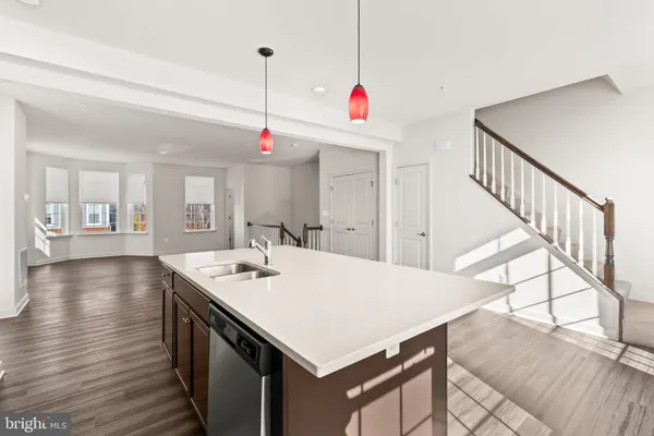 a kitchen with stainless steel appliances granite countertop a stove a refrigerator a sink dishwasher and a oven with wooden floor