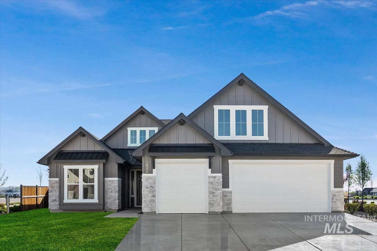 Craftsman-style house featuring board and batten siding, driveway, stone siding, and an attached garage