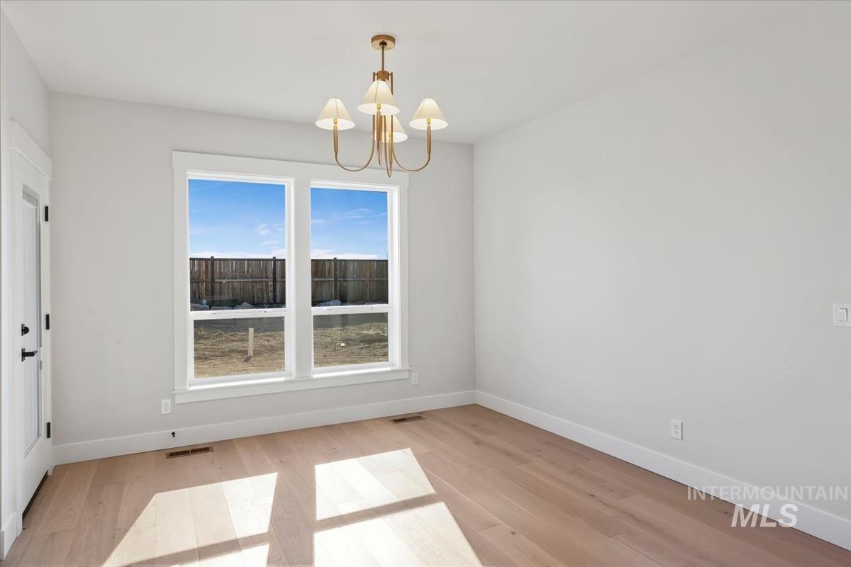 232 South Fusion Avenue Kuna, ID 83634 - Photo 19 of 50 Unfurnished dining area with suspended lighting and light wood-style floors