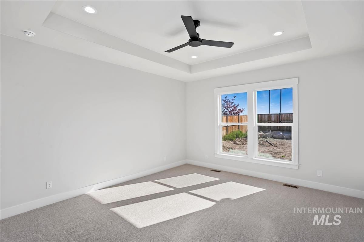 232 South Fusion Avenue Kuna, ID 83634 - Photo 24 of 50 Empty room with carpet floors, a raised ceiling, ceiling fan, and recessed lighting