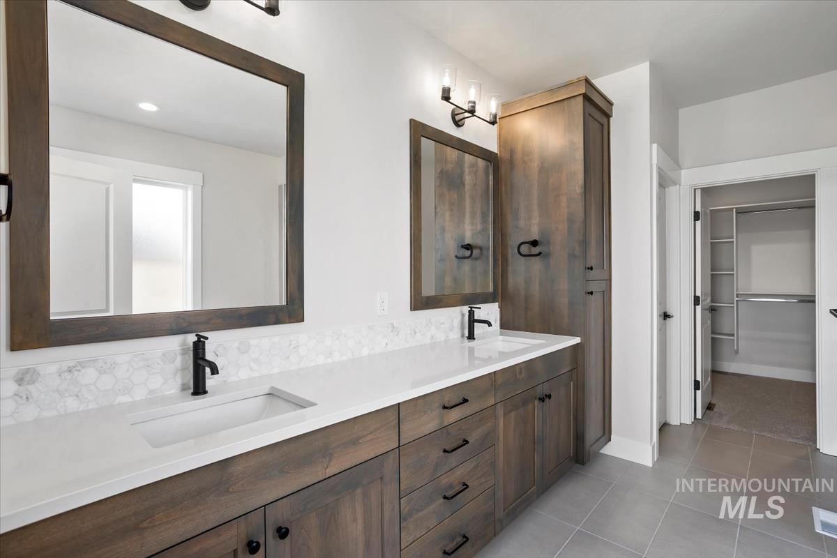 232 South Fusion Avenue Kuna, ID 83634 - Photo 26 of 50 Bathroom with double vanity, a walk in closet, and light tile patterned flooring