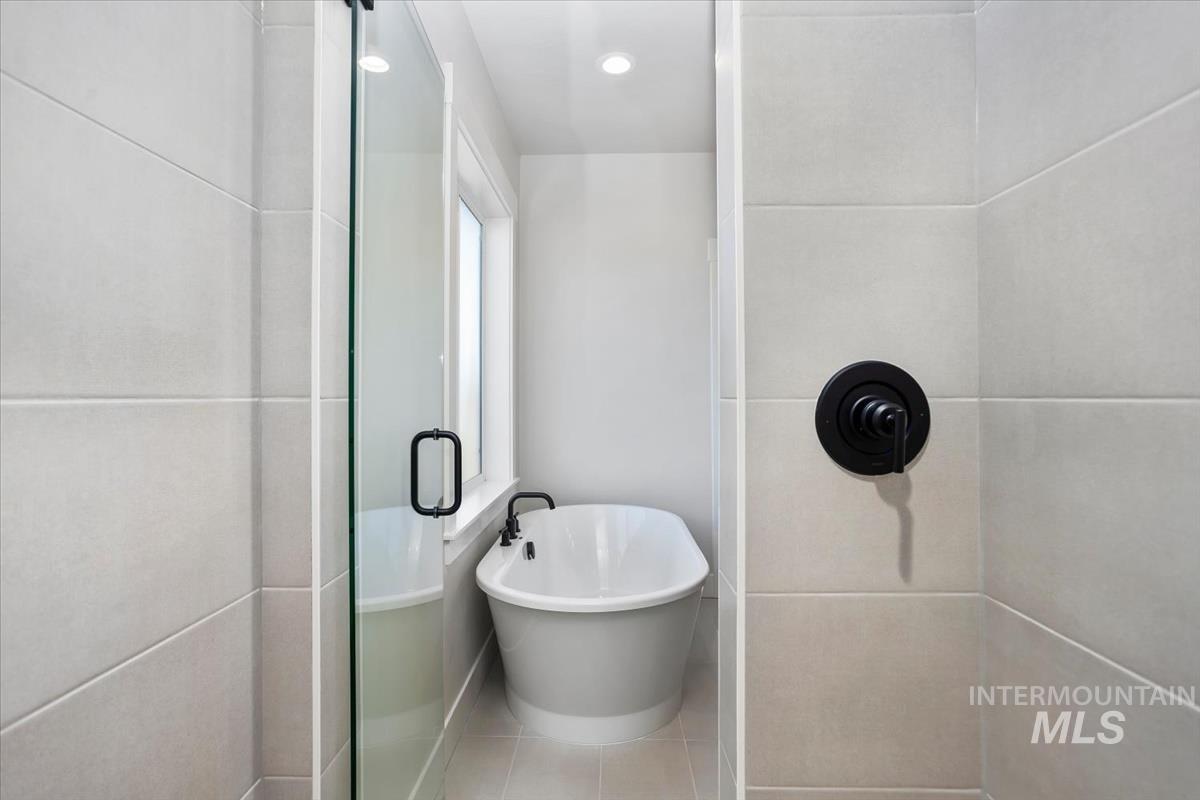 232 South Fusion Avenue Kuna, ID 83634 - Photo 29 of 50 Bathroom featuring a soaking tub, a stall shower, recessed lighting, and tile patterned flooring