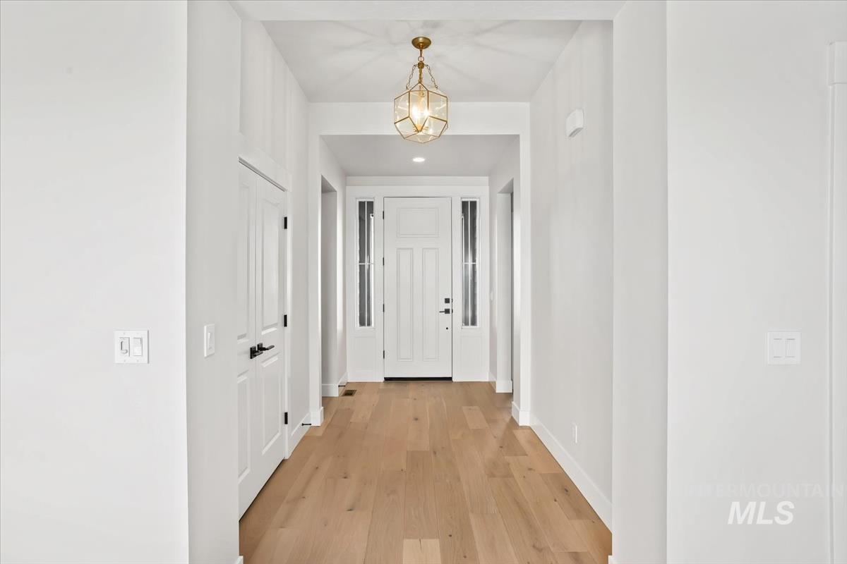 232 South Fusion Avenue Kuna, ID 83634 - Photo 5 of 50 Corridor featuring light wood-style floors and a chandelier