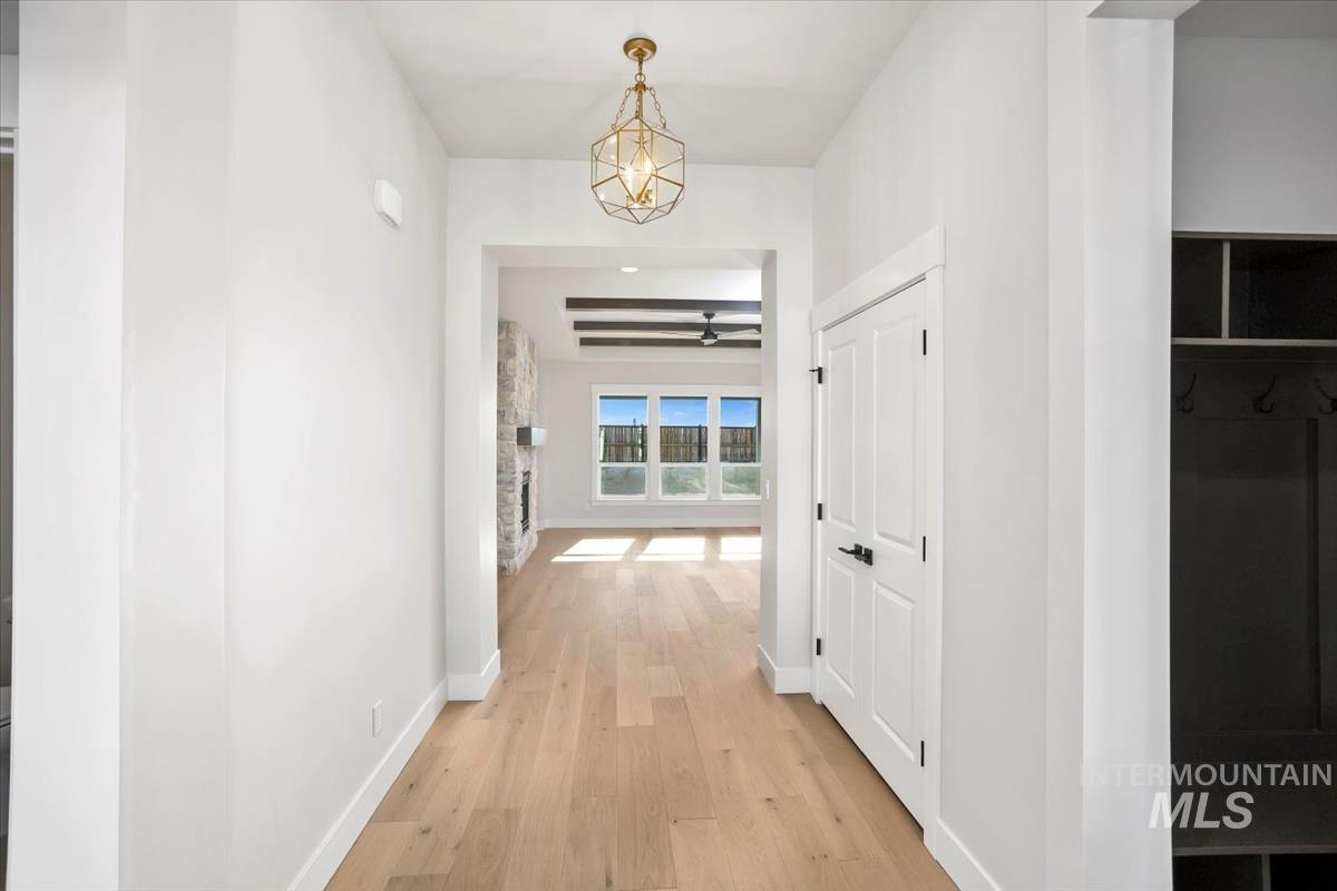 232 South Fusion Avenue Kuna, ID 83634 - Photo 6 of 50 Hallway featuring light wood finished floors and beam ceiling