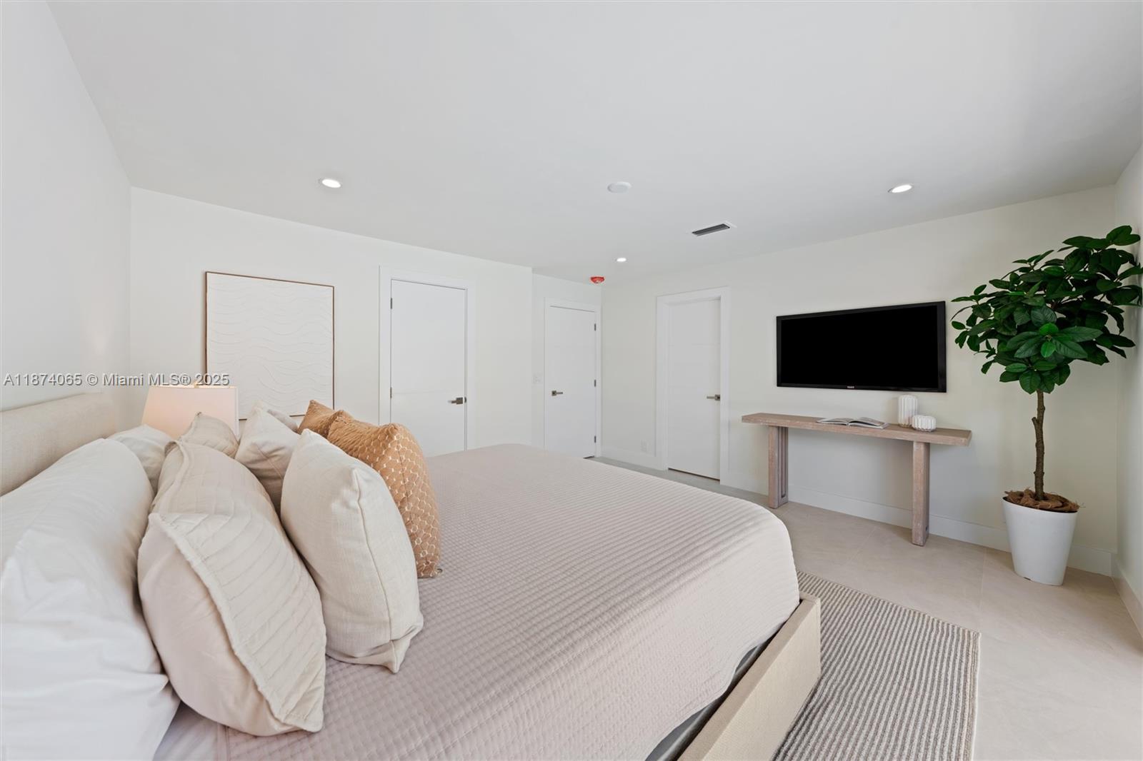 3041 Northeast 45th Street Lighthouse Point, FL 33064 - Photo 12 of 20 a bedroom with a bed tv and table