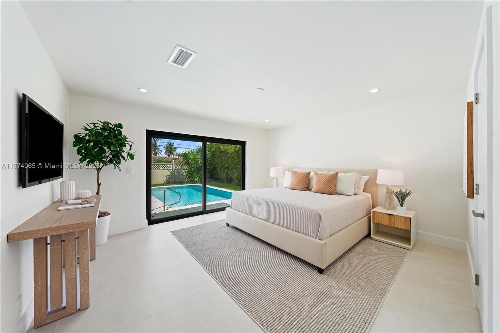 3041 Northeast 45th Street Lighthouse Point, FL 33064 - Photo 10 of 20 a spacious bedroom with a large bed and a flat screen tv