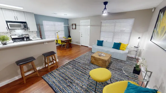a living room with furniture and a wooden floor
