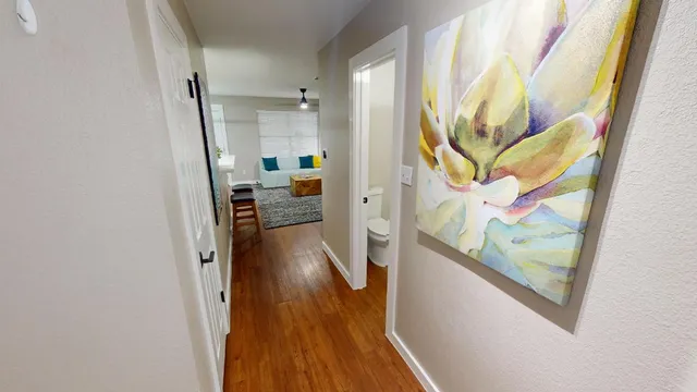 a view of a hallway with wooden floor and furniture