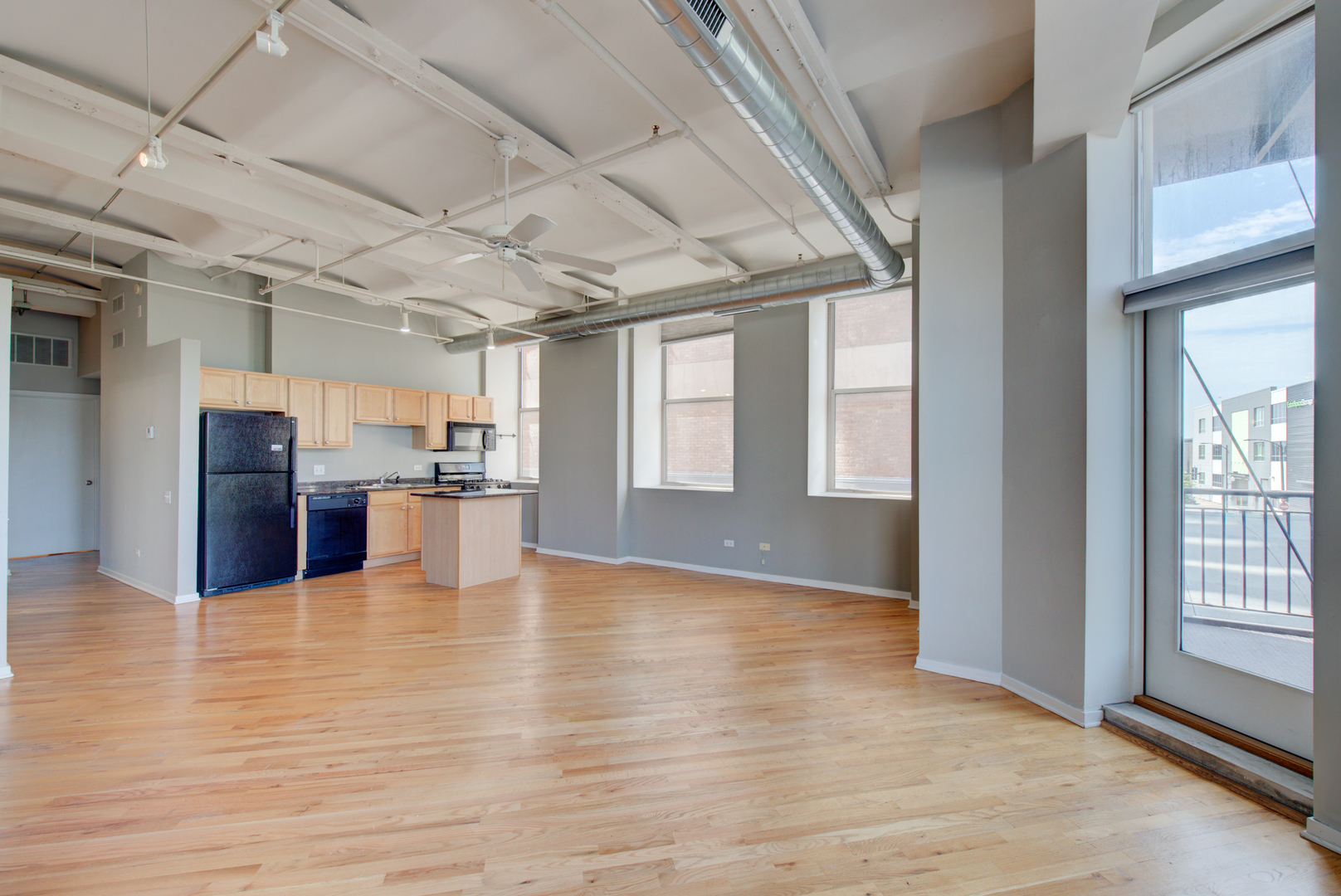 500 South Clinton Street, Unit 230 Chicago, IL 60607 - Photo 6 of 31 a view of an empty room with wooden floor and a kitchen