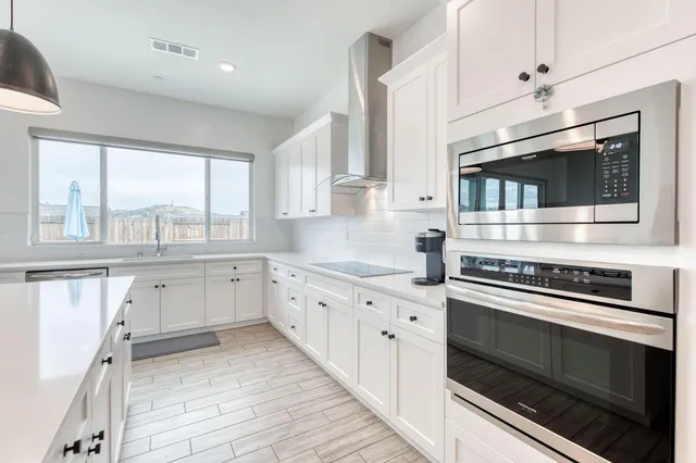 a kitchen with stainless steel appliances a stove sink and microwave