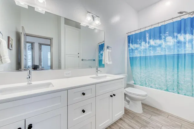 a bathroom with a granite countertop sink a toilet and a mirror