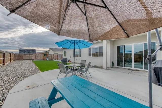 a patio with a table and chairs under an umbrella
