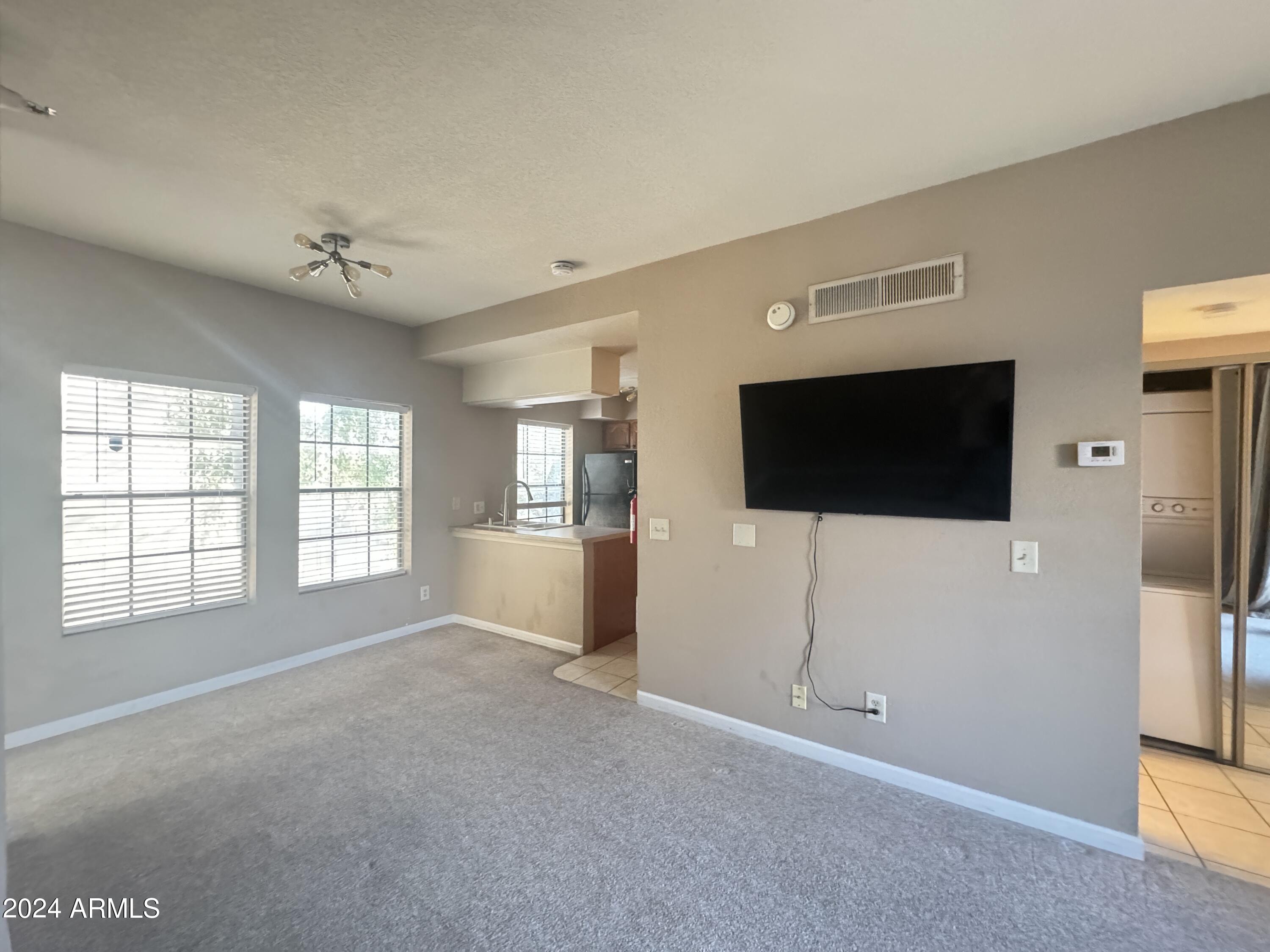 8020 East Thomas Road, Unit 226 Scottsdale, AZ 85251 - Photo 7 of 16 a view of an empty room with a window and wooden floor