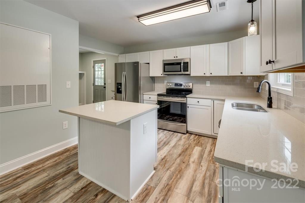 6973 Narrow Lane Road Hickory Grove, SC 29717 - Photo 12 of 35 a kitchen with stainless steel appliances white cabinets a sink a stove a refrigerator and white cabinets