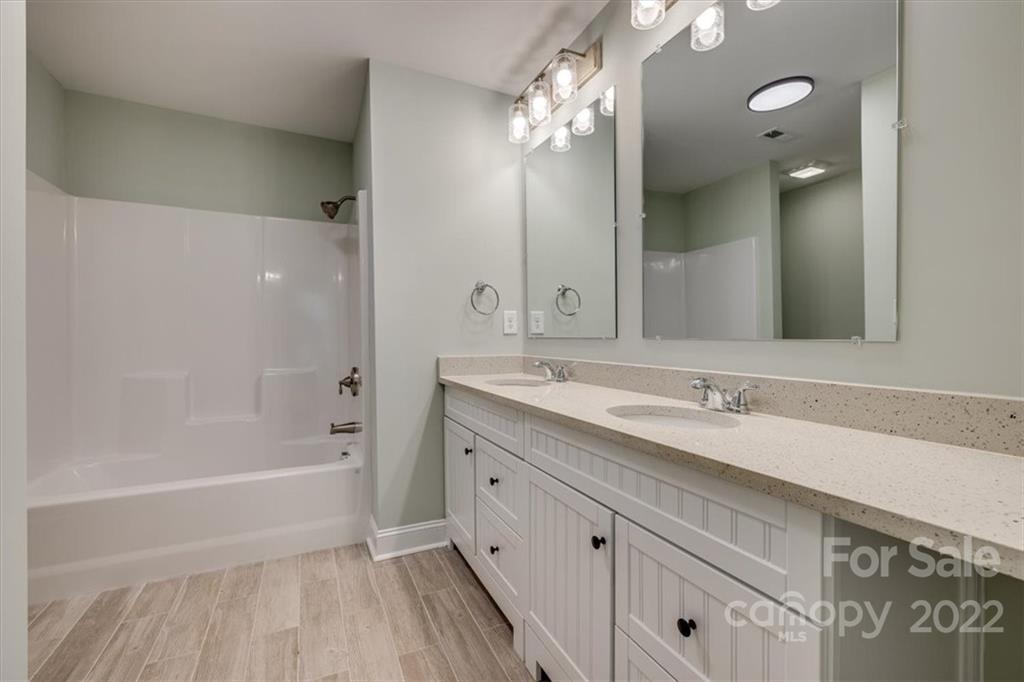 6973 Narrow Lane Road Hickory Grove, SC 29717 - Photo 19 of 35 a bathroom with a tub sink double vanity and a mirror