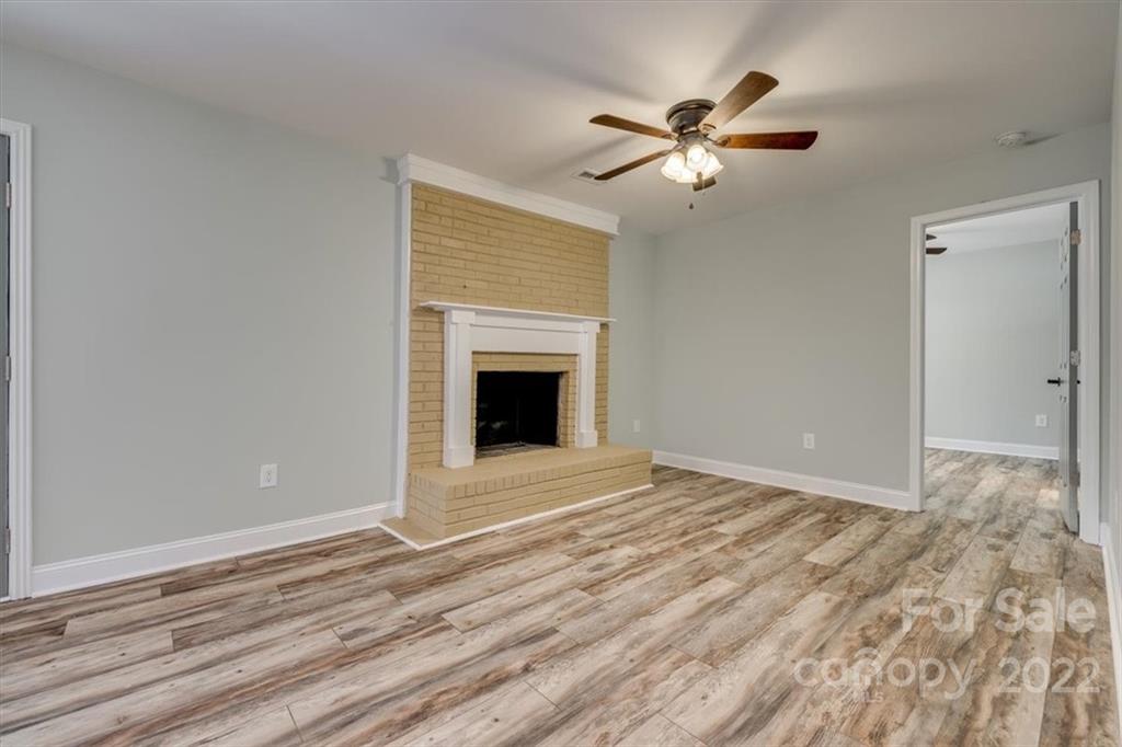 6973 Narrow Lane Road Hickory Grove, SC 29717 - Photo 6 of 35 a view of an empty room with wooden floor and a ceiling fan