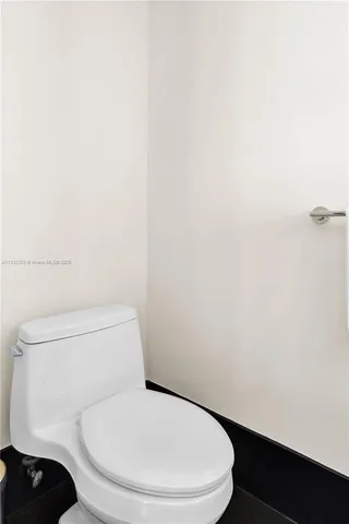 a white toilet sitting next to a white wall