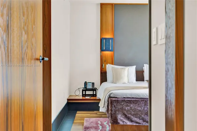 a bed room with a bed and a painting on the wall