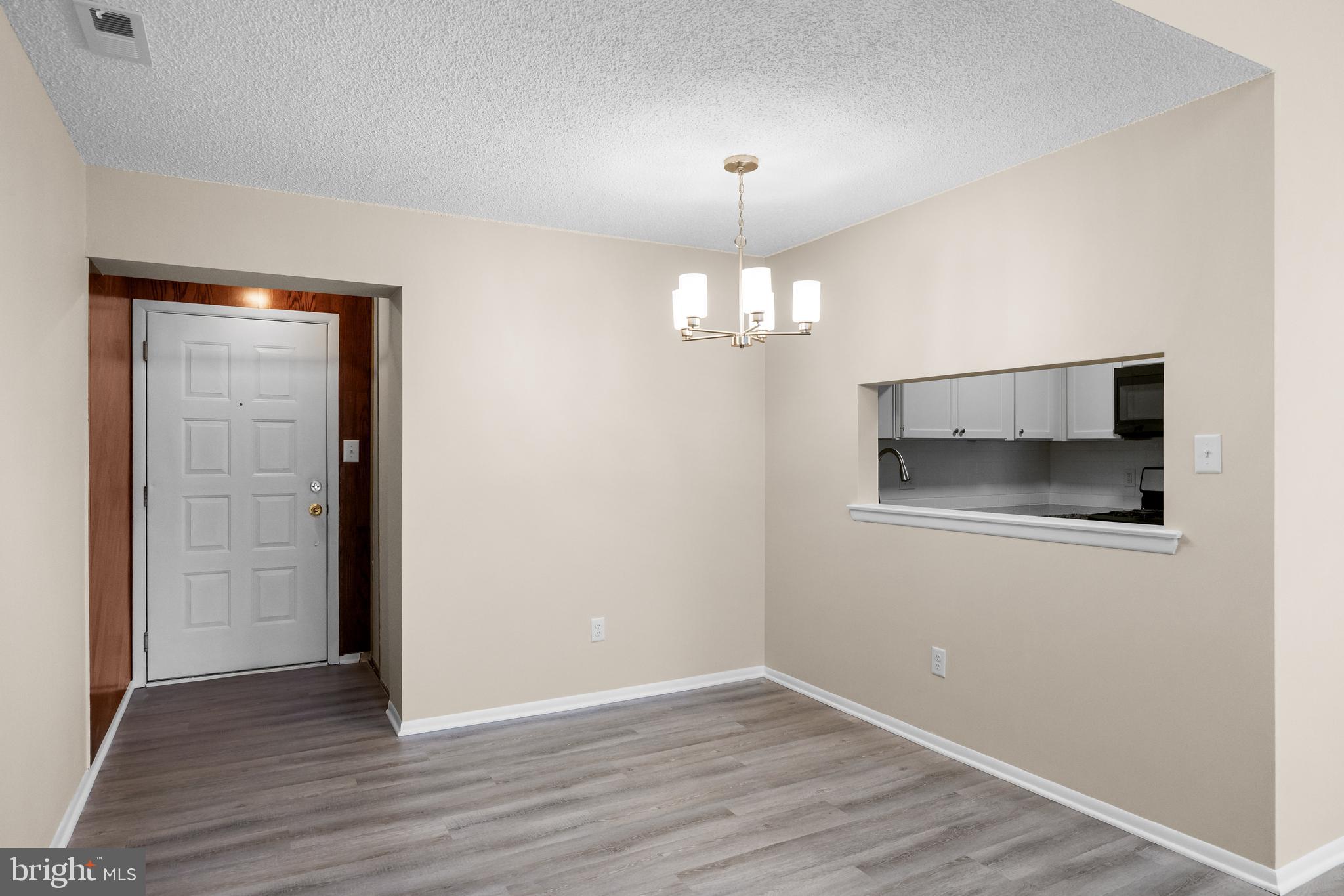 4904B Dunbarton Road Mount Laurel, NJ 08054 - Photo 8 of 27 an empty room with wooden floor and chandelier