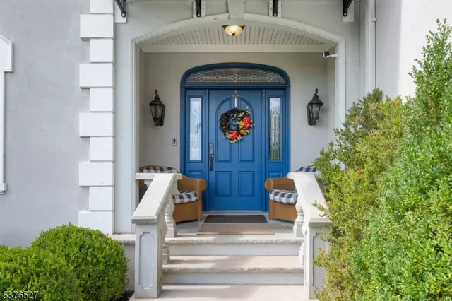 a front view of a house with a front door and potted plants