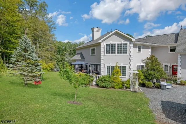 a front view of a house with a yard and potted plants