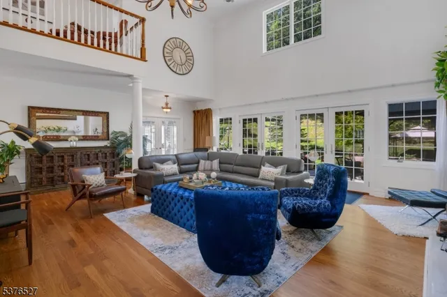 a living room with furniture a clock on wall and a window
