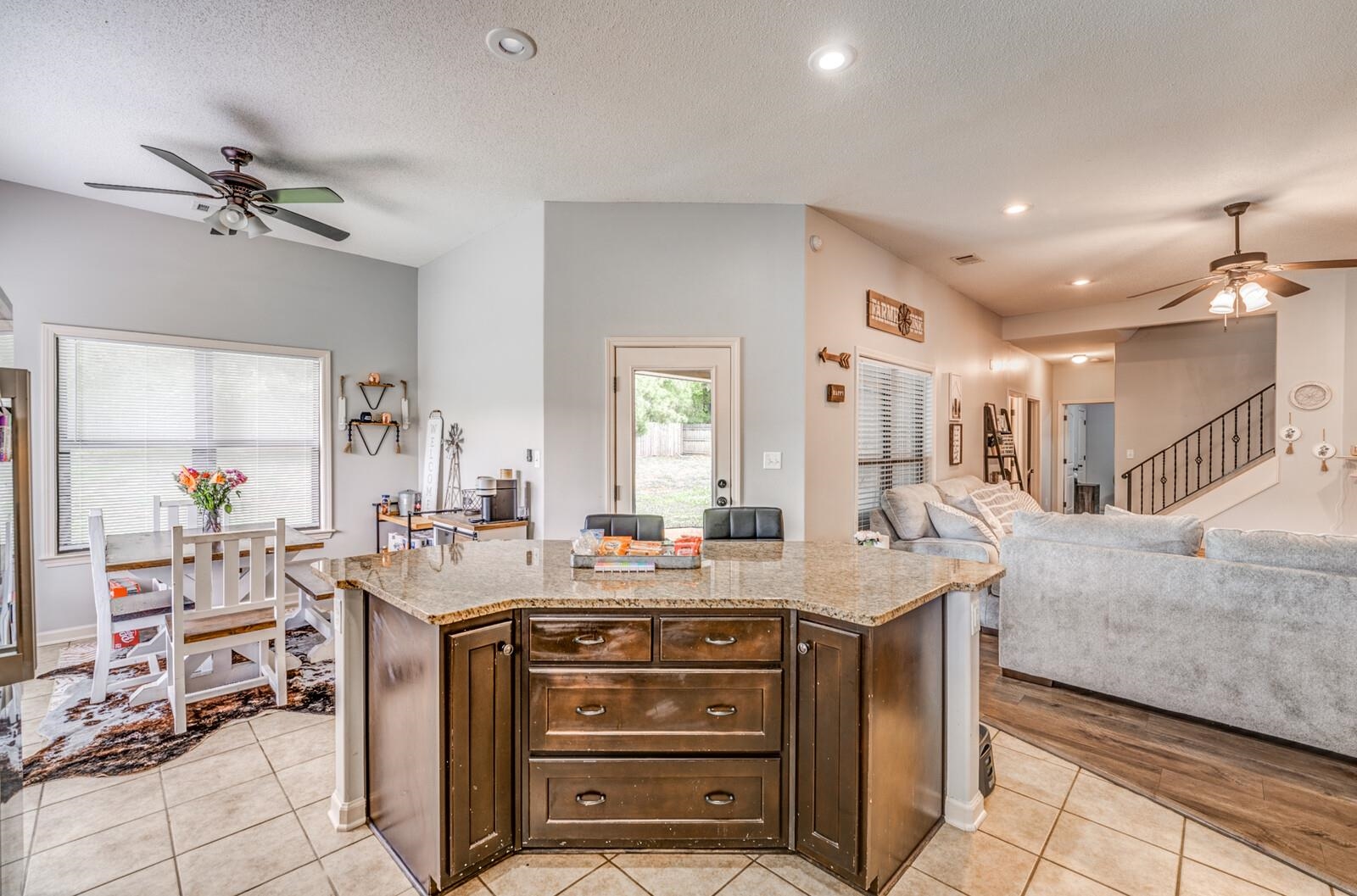 4671 Hampton Ridge Lane Bartlett, TN 38002 - Photo 21 of 40 Open-concept kitchen featuring an eat-at island with a speckled countertop and dark wood-finish cabinetry