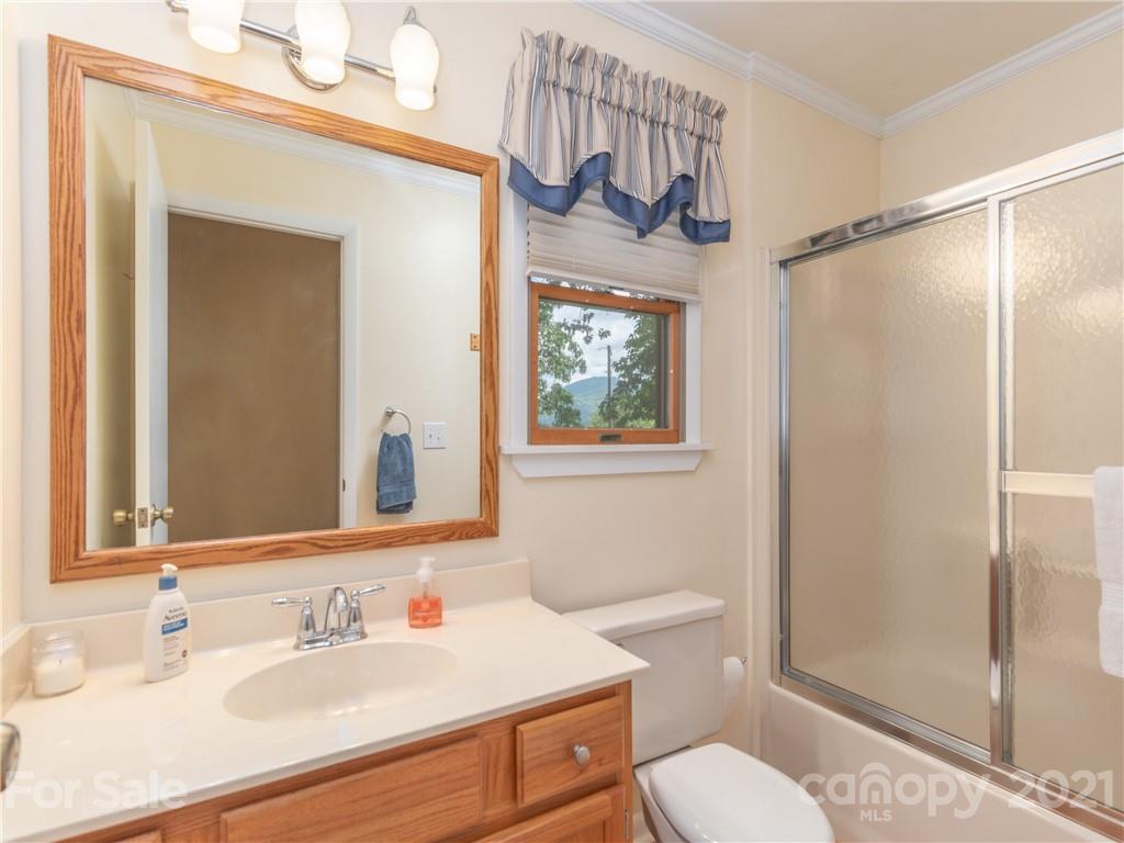 311 Walnut Ford Road Waynesville, NC 28785 - Photo 14 of 33 a bathroom with a sink a toilet a mirror and shower