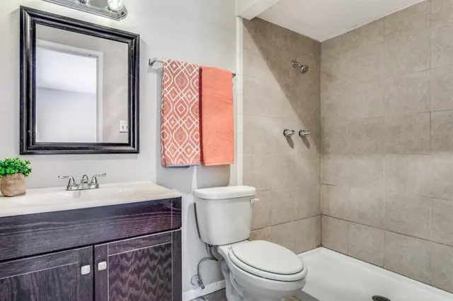 a bathroom with a sink a toilet and shower