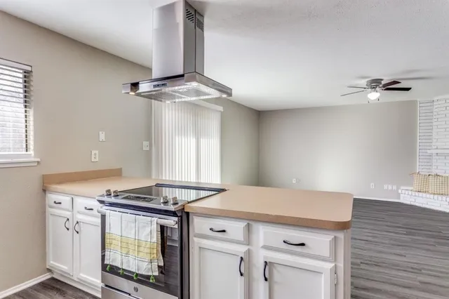 a kitchen with a stove and white cabinets