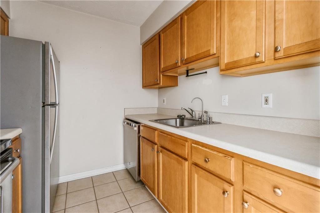 3155 Seven Pines, Unit 303 Atlanta, GA 30339 - Photo 10 of 25 a kitchen with stainless steel appliances granite countertop a sink a refrigerator and cabinets