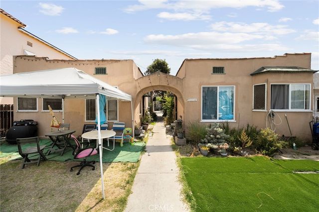 a view of a white house with iron fence